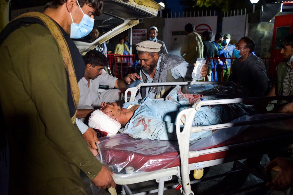 Medical and hospital staff bring an injured man on a stretcher for treatment