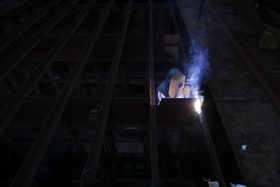 In this Wednesday, Feb. 12, 2014 photo a welder works at a dry dock in a shipyard in the depressed Perama area, on the fringes of Athens' port of Piraeus. For Perama, the ships have sailed. Until recently, this working class town at Athens’ western tip hosted some of the busiest shipyards in Greece, a maritime country with one of the world’s biggest shipping industries. Perama’s unemployment is among the worst in Greece, where the nationwide figure for November was 28 percent, according to the statistical authority on Thursday, Feb. 13, 2014. (AP Photo/Thanassis Stavrakis)