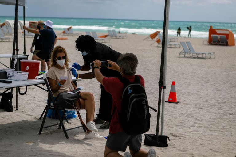 Una mujer recibe la dosis de Johnson & Johnson en una playa de South Beach, Florida