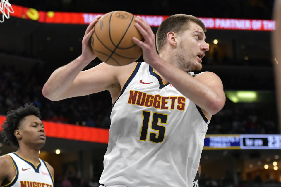 Denver Nuggets center Nikola Jokic (15) handles the ball in the first half of an NBA basketball game against the Memphis Grizzlies, Sunday, April 14, 2024, in Memphis, Tenn. (AP Photo/Brandon Dill)