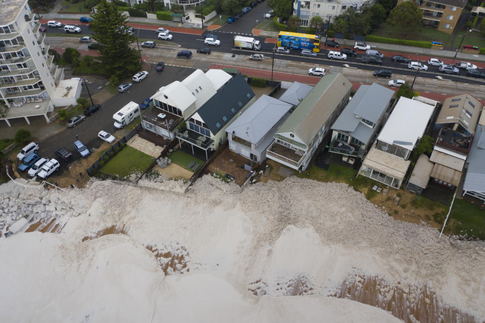 Ocean waves surge towards a number of houses. Source: Getty Images