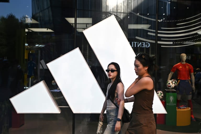 Dos personas pasan frente a una tienda de Adidas en un centro comercial de Pekín, el 16 de junio de 2024 (Pedro Pardo)