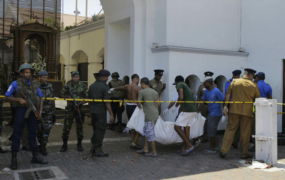 Sri Lankans carry a dead body following a blast at the St. Anthony's Church in Colombo, Sri Lanka, Sunday, April 21, 2019. More than hundred people were killed and hundreds more hospitalized from injuries in near simultaneous blasts that rocked three churches and three luxury hotels in Sri Lanka on Easter Sunday, a security official told The Associated Press, in the biggest violence in the South Asian country since its civil war ended a decade ago.(AP Photo/Eranga Jayawardena)