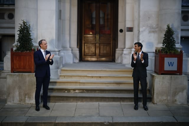 Foreign Secretary Dominic Raab, left, and Chancellor Rishi Sunak clapping outside the Foreign and Commonwealth Office in London to salute local heroes during Thursday’s nationwide Clap for Carers initiative