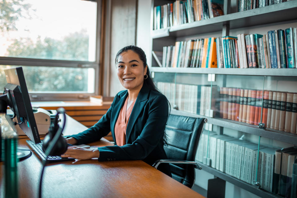 A woman sitting at a desk inside a library