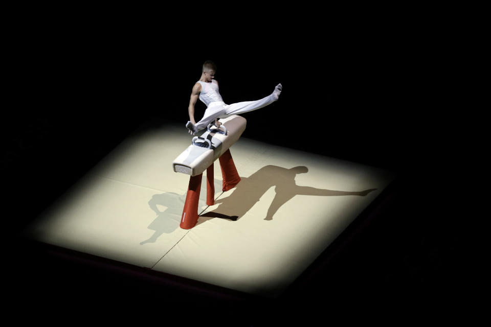 A gymnast performs during a presentation before the start of an Artistic Gymnastics men's qualification round at the 2012 Summer Olympics, Saturday, July 28, 2012, in London. (AP Photo/Julie Jacobson)