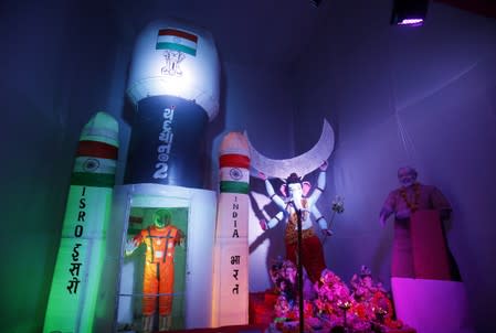 A model of India's Geosynchronous Satellite Launch Vehicle Mk III-M1, which carried Chandrayaan-2, and a cut-out of India's PM Modi is seen next to an idol of the Hindu god Ganesh, the deity of prosperity, in Ahmedabad