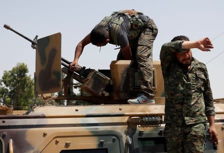 A Kurdish fighter from the People's Protection Units (YPG) adjusts a gun on top of an armored vehicle in Raqqa, Syria July 2, 2017. REUTERS/Goran Tomasevic