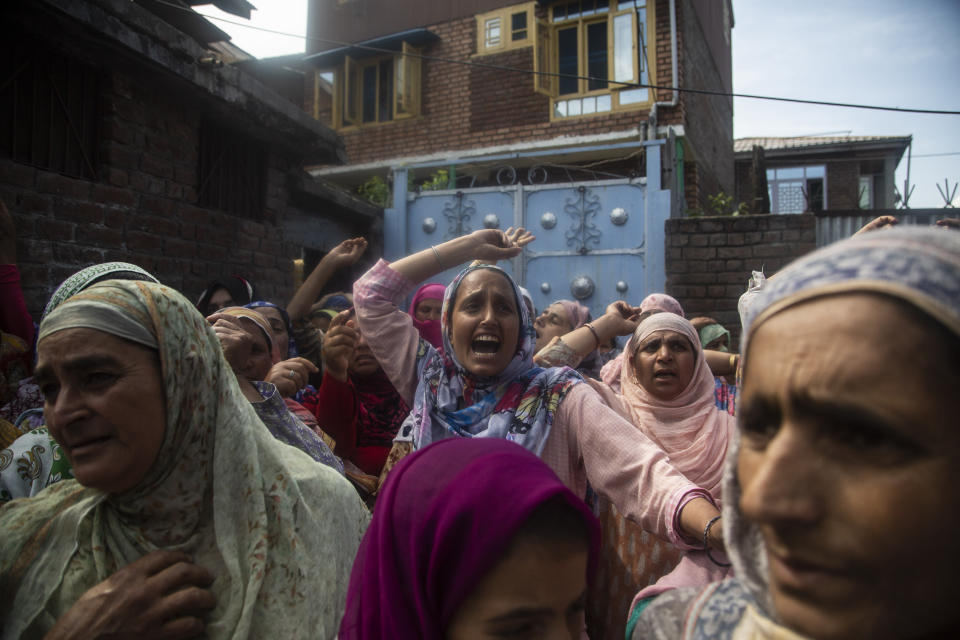 Kashmiri woman shout freedom slogans near the body of Bashir Ahmad, a civilian killed in a shootout, during his funeral at Sopore, 55 kilometers (34 miles) north of Srinagar, Indian controlled Kashmir, Saturday, June 12, 2021. Two civilians and two police officials were killed in an armed clash in Indian-controlled Kashmir on Saturday, police said, triggering anti-India protests who accused the police of targeting the civilians. (AP Photo/Mukhtar Khan)
