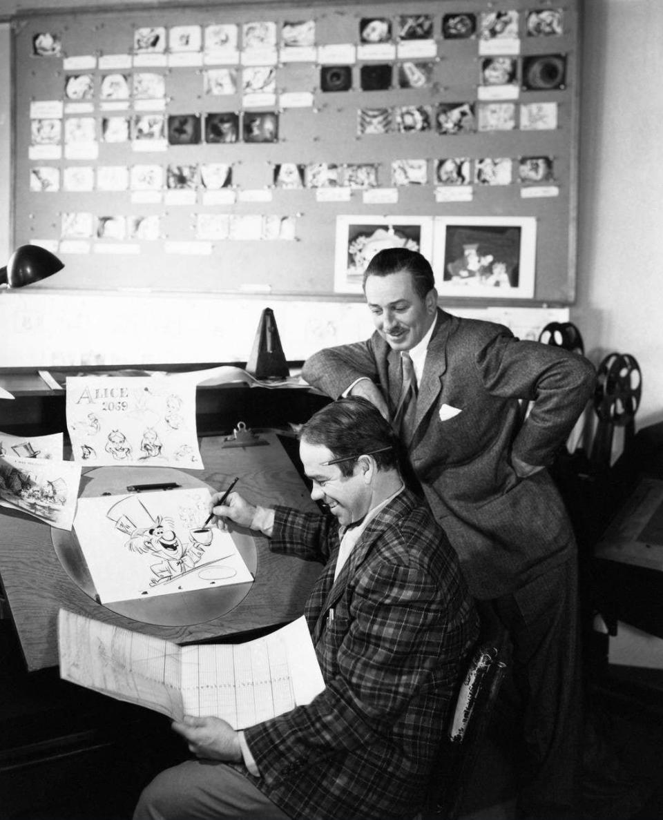 ALICE IN WONDERLAND, from left: animator Ward Kimball works on a drawing of The Mad Hatter as producer Walt Disney looks on - Alamy