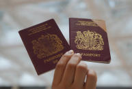 A protester holds up the British National (Overseas) passports in a shopping mall during a protest against China's national security legislation for the city, in Hong Kong, Monday, June 1, 2020. The mouthpiece of China's ruling Communist Party says U.S. moves to end some trading privileges extended to Hong Kong grossly interfere in China's internal affairs and are doomed to fail. (AP Photo/Vincent Yu)