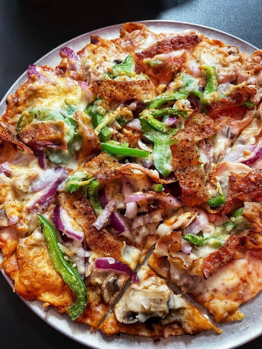 Deluxe Pizza on a serving tray, Imo’s Pizza, St. Louis, Missouri, on a grey table