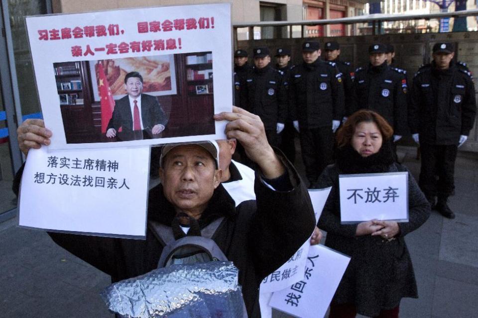 Relatives of passengers onboard the missing Malaysia Airlines Flight 370 demand for the Chinese government to continue the search, with banners showing Chinese President Xi Jinping and the words "Don't Give Up" near the Foreign Ministry in Beijing, China, Wednesday, March 8, 2017. Wednesday marked the third anniversary of the disappearance of MH370, which vanished March 8, 2014 while en route from Kuala Lumpur to Beijing. (AP Photo/Ng Han Guan)