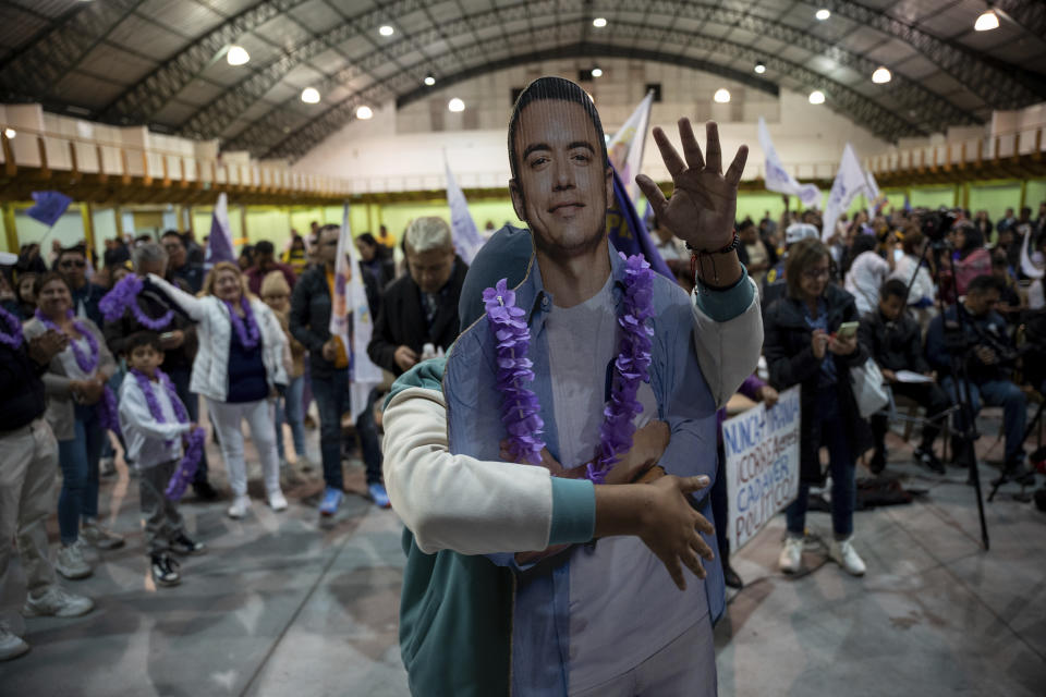 Un simpatizante del candidato presidencial Daniel Noboa con una imagen de cartón de Noboa celebra los primeros resultados del balotaje presidencial que le dan la ventaja al empresario, en Quito, Ecuador, el domingo 15 de octubre de 2023. (AP Foto/Carlos Noriega)