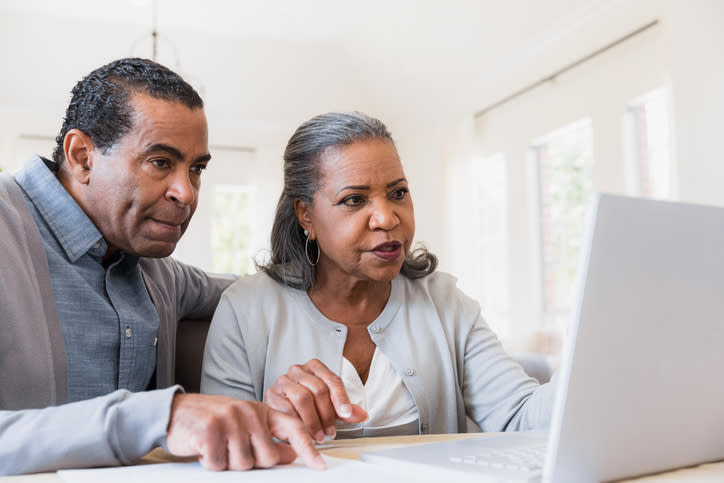 A retired couple looks over their finances as they decide whether to use retirement savings to pay off their mortgage.