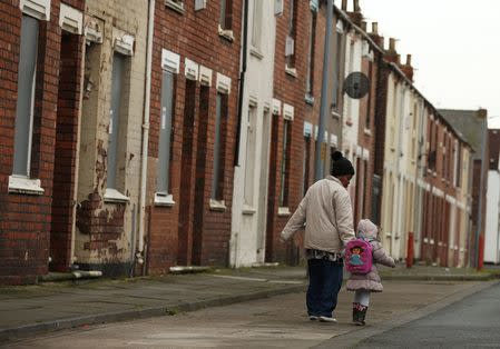 A woman and child walk along a terraced street in the Gresham area of Middlesbrough, northern Britain, January 20, 2016. REUTERS/Phil Noble