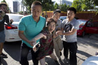 <p>A woman is dragged away by Chinese men moments after she was seen talking to journalists near the site of a reported explosion outside the U.S. Embassy in Beijing, Thursday, July 26, 2018. (Photo: Ng Han Guan/AP) </p>