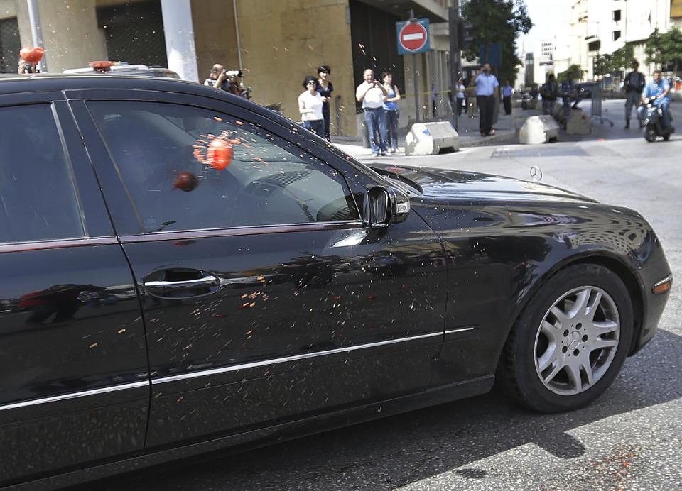 FILE - In this May 31, 2013, file photo, Lebanese lawmaker Imad al-Hout, who represents the Islamic group, is seen through his car window as it is pelted with tomatoes by pro-democracy protesters during a protest against the 17-month extending of the Lebanese parliament, in Beirut, Lebanon. Since the current parliament was elected in June 2009, the lawmakers have met 21 times to pass 169 laws, mostly related to raise government and civil servants' salaries, receive foreign aid and amend election law that will enable their re-election. In 2013, Lebanon's lawmakers only met twice to pass two laws, one of which was to extended their mandate for 18 months. (AP Photo/Hussein Malla, File)