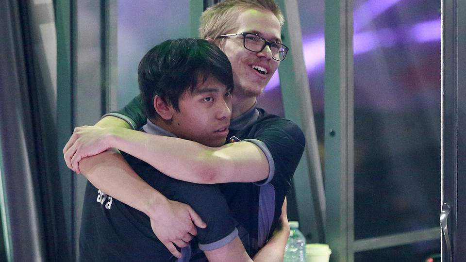 Anathan Pham (L) and Topias Taavitsainen of OG hug after their 3-2 win over PSG.LGD in their grand final Dota 2 match. (Photo by Jeff Vinnick/Getty Images)