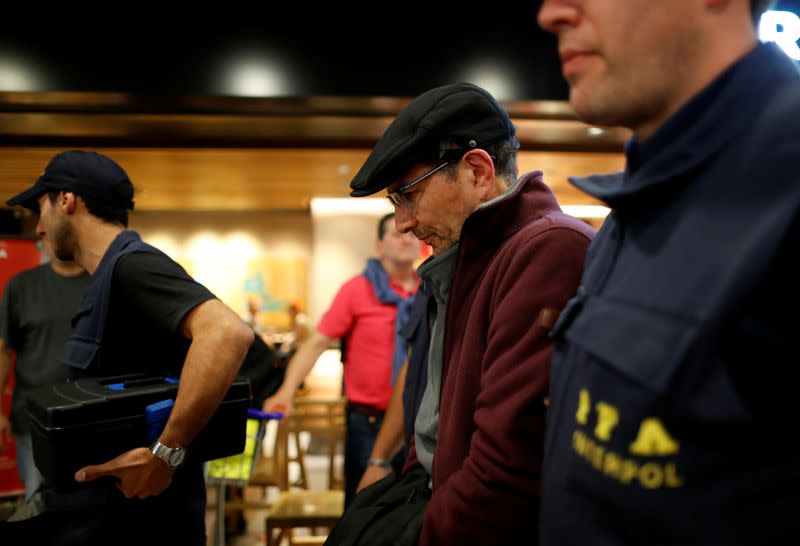 Mario Sandoval is escorted by police officers at Ministro Pistarini international airport after being extradited from France, in Buenos Aires