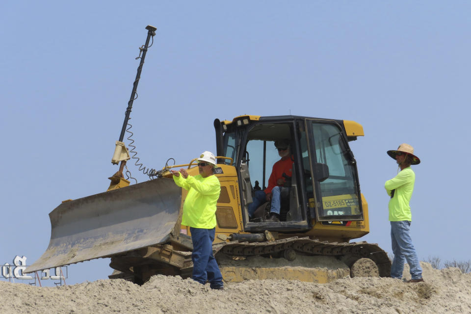 A bulldozer reshapes a sand dune on the North Wildwood, N.J. beach on May 22, 2023, carrying out emergency work approved by New Jersey officials. But the city did another dune reshaping weeks later that has drawn the threats of additional penalties beyond the $12 million the state has already imposed for unauthorized beach work. (AP Photo/Wayne Parry)