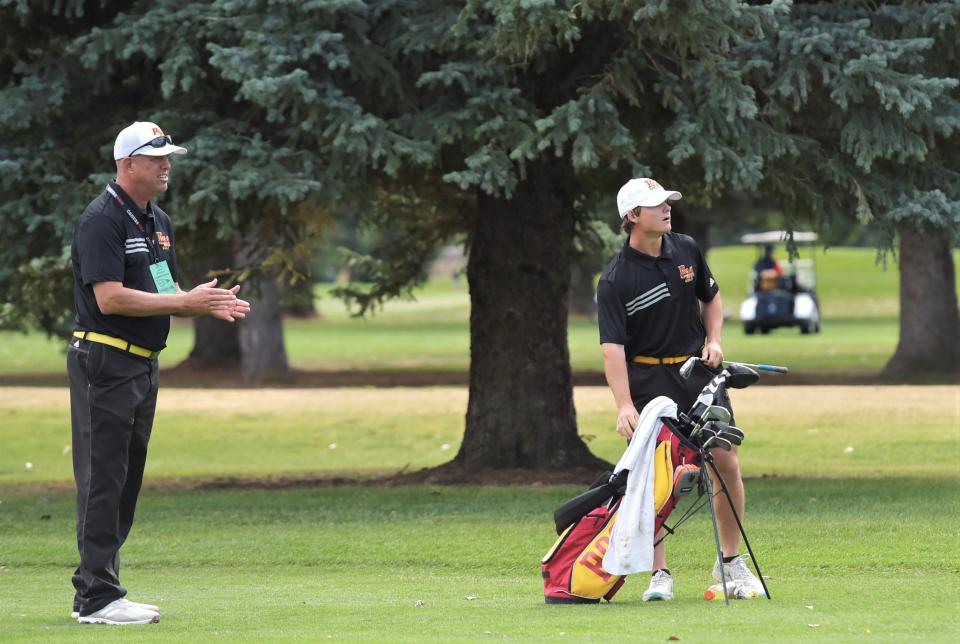 Rocky Mountain golfer Sam Kainer-Darst eyes his approach shot as Lobos' head coach Scott Morris applauds it during the Colorado 5A boys golf state championships on Tuesday, Oct. 3, 2023 at Collindale Golf Course in Fort Collins, Colo.