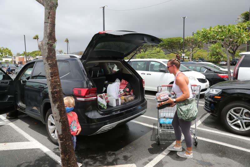 Honolulu resident Beth Frazzilini loads her car with supplies to ride out Hurricane Douglas in Honolulu