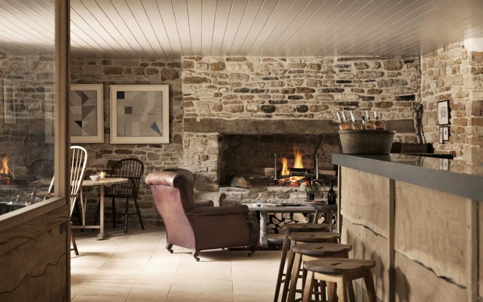 The interior of the Wild Rabbit, a bar and an armchair next to an unlit fireplace