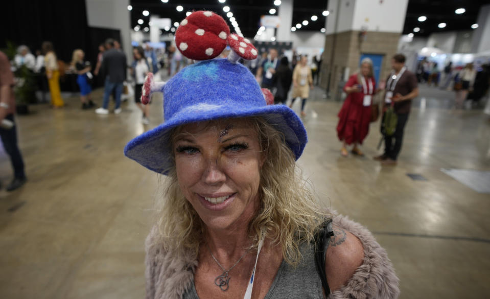 Julia Ward of Houston wears a hat adorned with mushrooms while touring the exhibitors' displays at the Psychedelic Science conference in the Colorado Convention Center Wednesday, June 21, 2023, in Denver. (AP Photo/David Zalubowski)