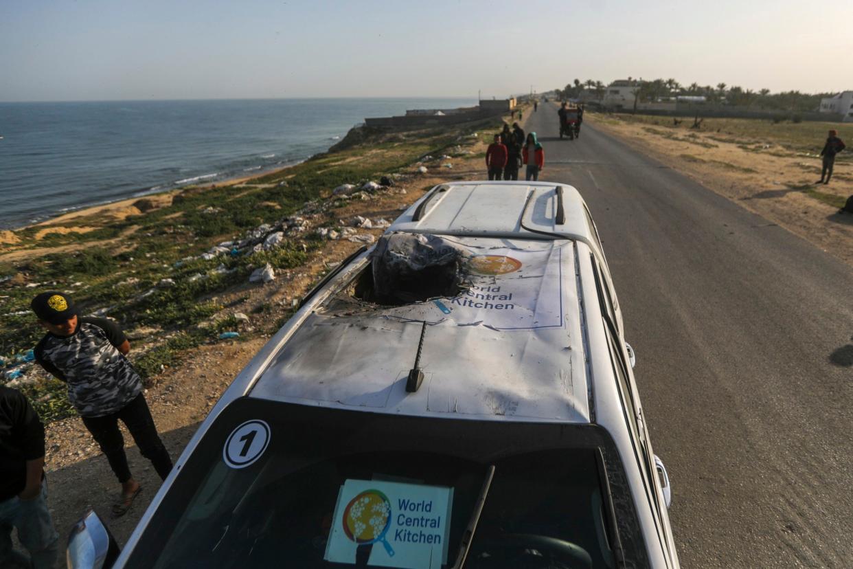 Palestinians inspect a vehicle with the logo of the World Central Kitchen wrecked by an Israeli airstrike in Deir al Balah, Gaza Strip