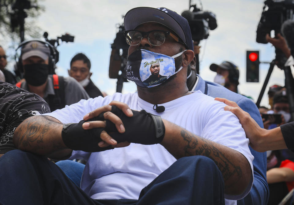 FILE - In this June 1, 2020, file photo, Terrence Floyd sits silently in the spot at the intersection of 38th Street and Chicago Avenue in Minneapolis, Minn., where his brother, George Floyd, encountered police a week earlier and died while in their custody. Terrence Floyd, who urged calm amid nationwide violent unrest and protests in June, is following up on his emotional plea to protesters with a message to channel their power at the ballot box. (AP Photo/Bebeto Matthews, File)