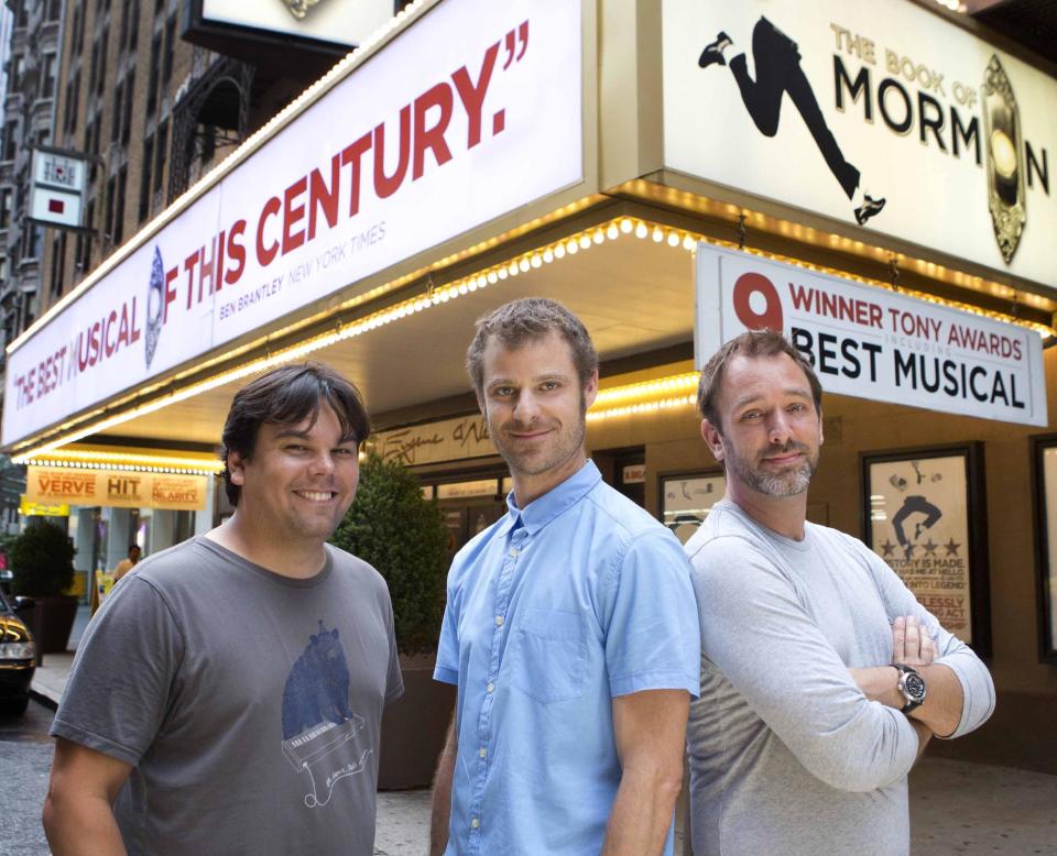 This July 2012 image released by Boneau/Bryan-Brown shows, from left, Robert Lopez, Matt Stone and Trey Parker are shown in front of the Eugene O'Neill theater where the Tony-award winning musical "The Book of Mormon," is performing in New York. The nine-time Tony Award-winning musical opens its first national tour in Denver this month. (AP Photo/Boneau/Bryan-Brown, Joan Marcus)