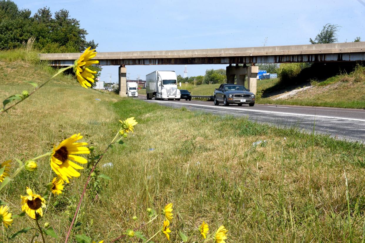 Interstate 70 traffic moves eastbound below the I-70 westbound exit ramp bridge that leads to Business Loop 70 on Monday.