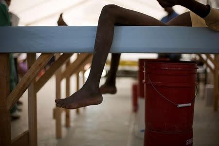 Boys lie on cholera beds, cots with a hole cut into the center and a bucket underneath, in the intake tent at a cholera clinic set up by Medecins sans Frontieres in the Tabarre neighborhood of Port-au-Prince, Haiti, November 19, 2010. REUTERS/Allison Shelley/File Photo