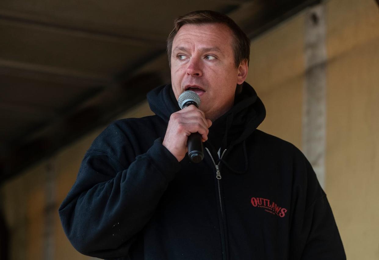 Chris Scott, owner of the Whistle Stop Cafe speaks during a rally against public health orders in 2021 at his cafe in Mirror, Alta. At the time, Scott was charged with breaking the orders. On Monday, Scott was acquitted on all charges.  (Jason Franson/The Canadian Press - image credit)