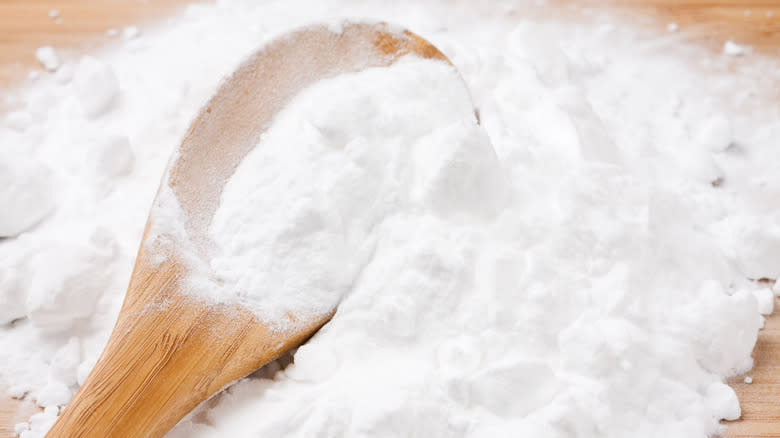 baking soda spilled over a wooden spoon