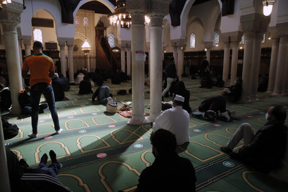 FILE - Muslims pray during the first day of the holy fasting month of Ramadan, at the Paris Mosque, Tuesday, April 13, 2021. The French government on Saturday, Feb. 5, 2022, forged ahead with efforts to reshape Islam in France and rid it of extremism, introducing a new body made up of clergy and laymen — and women — to help lead the largest Muslim community in western Europe. (AP Photo/Christophe Ena, File)