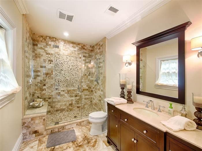 <p>One of the guest bathrooms has a granite vanity and textured marble tiles. Oh-so-chic.</p>