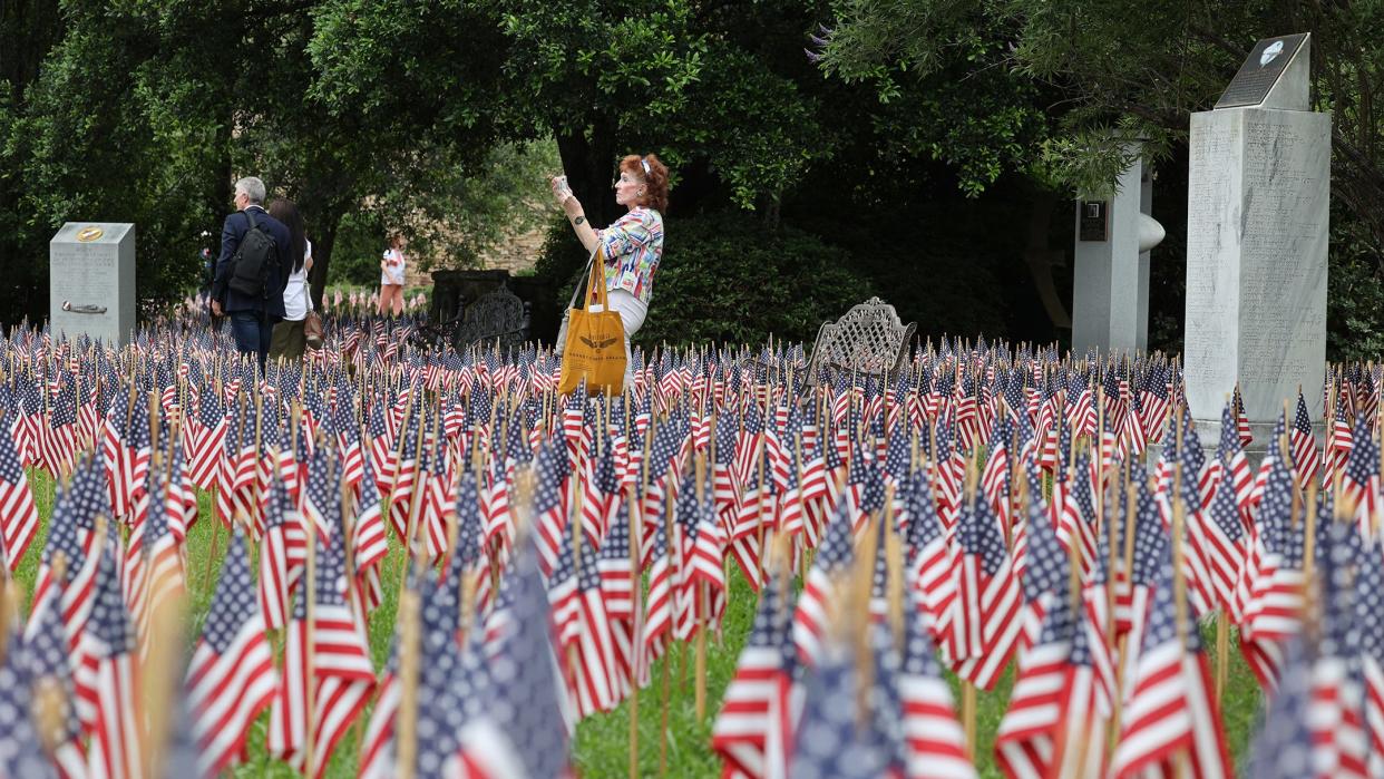 Visitors pause among the 26,000 flags in the garden of the National Museum of the Mighty 8th Air Force on Friday, May 26, 2023 during the 3rd annual Flags for the Fallen Memorial Day weekend event.