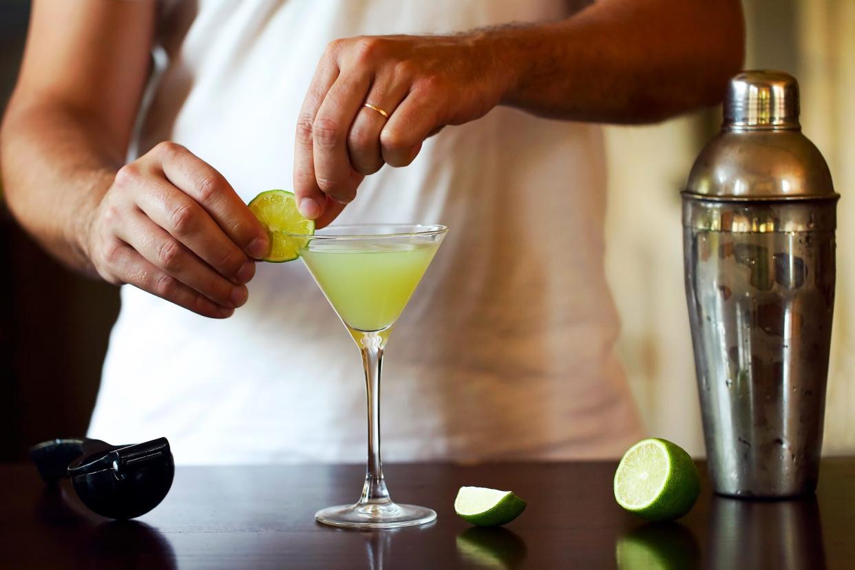 A person garnishes a freshly made cocktail