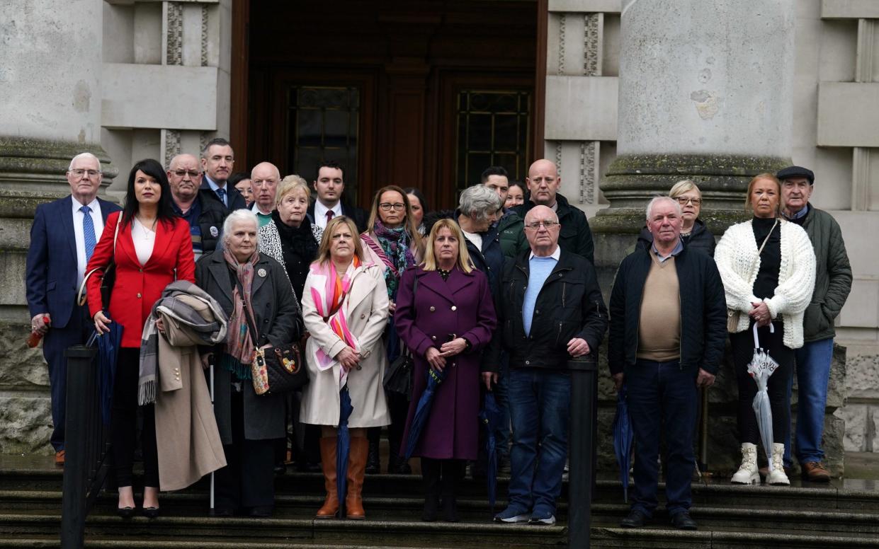 Survivors and families of victims outside the court