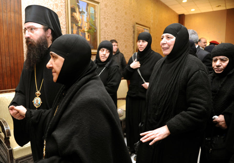 In this photo released by the Syrian official news agency SANA, a group of nuns who were freed after being held by rebels, greet church officials at the Syrian border town of Jdeidat Yabous, early Monday, March. 10, 2014. Rebels in Syria freed more than a dozen Greek Orthodox nuns on Monday, ending their three-month captivity in exchange for Syrian authorities releasing dozens of female prisoners. The release of the nuns and their helpers, 16 women in all, is a rare successful prisoner-exchange deal between Syrian government authorities and the rebels seeking to overthrow the rule of President Bashar Assad. (AP Photo/SANA)