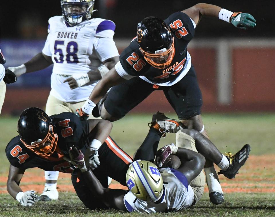 Ahmad “tooda" Hunter of Booker is tackled by James Nunnally and Adrian Smith of Cocoa in the FHSAA football Class 2S state semifinal Friday, December 1, 2023. Craig Bailey/FLORIDA TODAY via USA TODAY NETWORK
