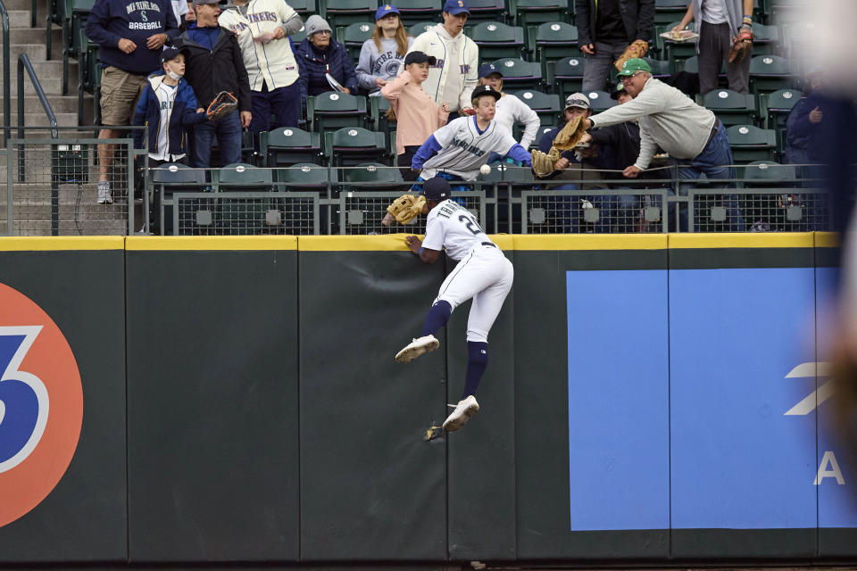 Seattle Mariners center fielder Taylor Trammell leaps but cannot catch a home run by Minnesota Twins' Byron Buxton during the first inning of a baseball game, Monday, June 13, 2022, in Seattle. (AP Photo/John Froschauer)