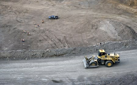 FILE PHOTO: Workers survey the base of the 500-foot-deep open pit at Molycorp's Mountain Pass Rare Earth facility in Mountain Pass, California