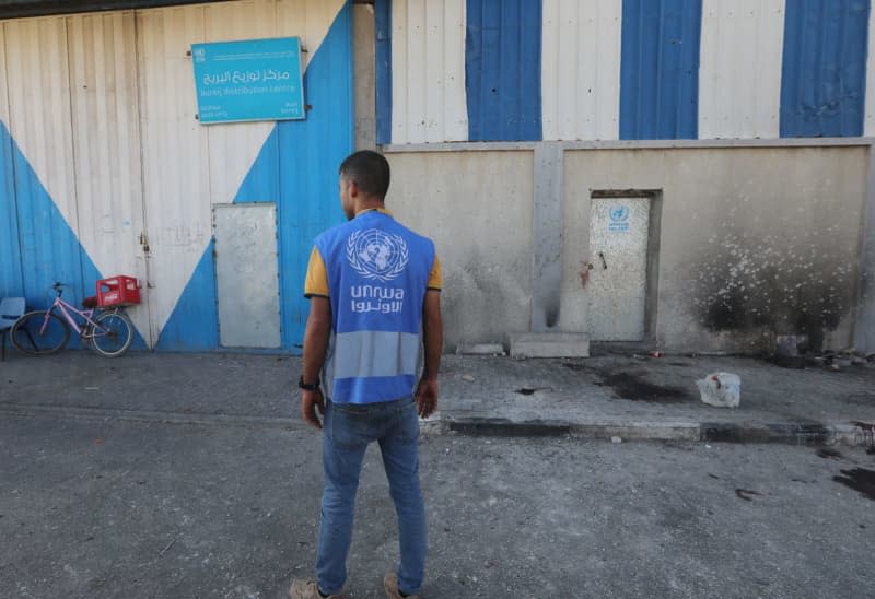 A staff of the United Nations Relief and Works Agency for Palestine Refugees in the Near East (UNRWA) stands in front of a warehouse belonging to the UNRWA which was destroyed by the Israeli army. Omar Ashtawy/APA Images via ZUMA Press Wire/dpa