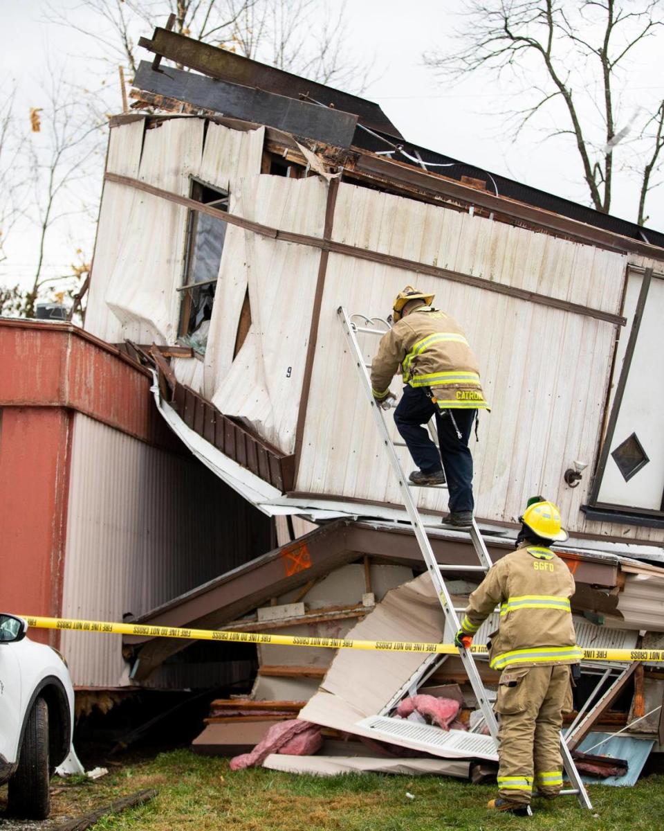 Firefighters work on marking mobile homes damaged and destroyed by a storm last night at Parkers Mobile Home Park in Stamping Ground, Ky., Saturday, December 6, 2021.