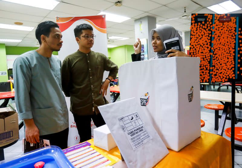 Hajar Wahab explains to her fellow undergraduates the process of casting a vote for Malaysia's upcoming general election at Gombak