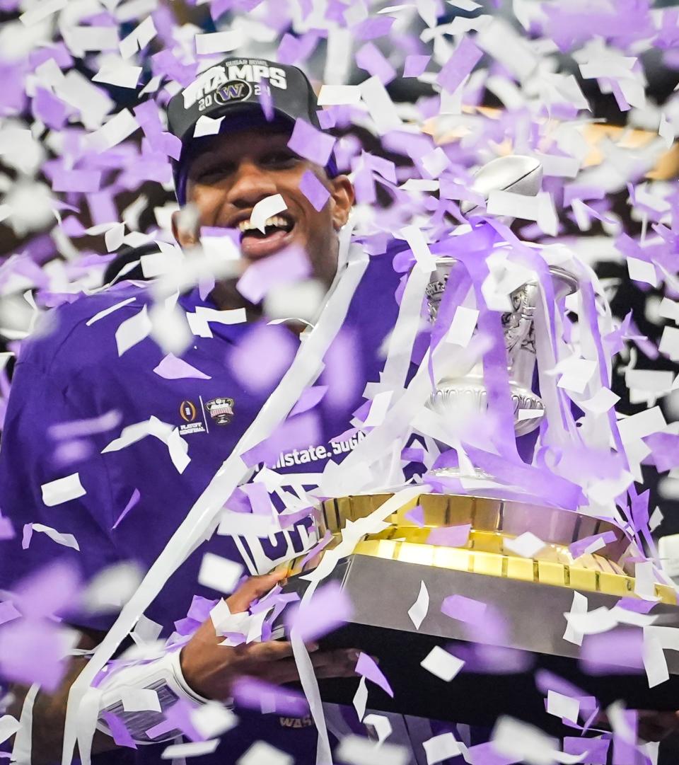 Washington quarterback Michael Penix Jr. holds the Sugar Bowl trophy after directing the Huskies to their 37-31 win, which also was their nation's best 21st straight victory. Just like last year's Alamo Bowl, Penix carved up the Longhorns' secondary; he finished with 430 passing yards.