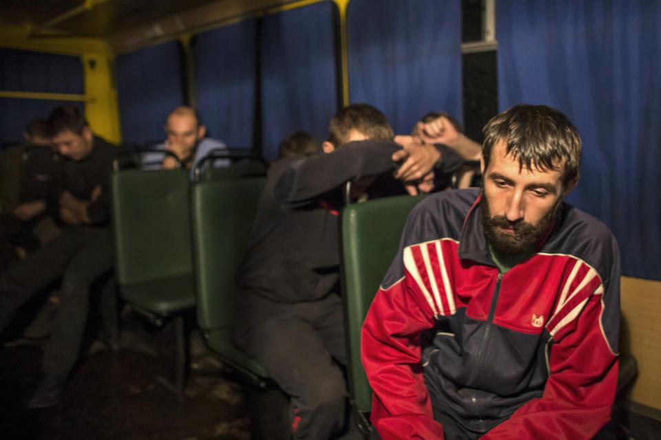 Members of the Ukrainian government forces, who are prisoners-of-war, sit in a bus as they wait to be exchanged, north of Donetsk, eastern Ukraine